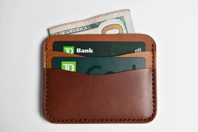 Brown leather card holder with cards placed in the visible front pockets