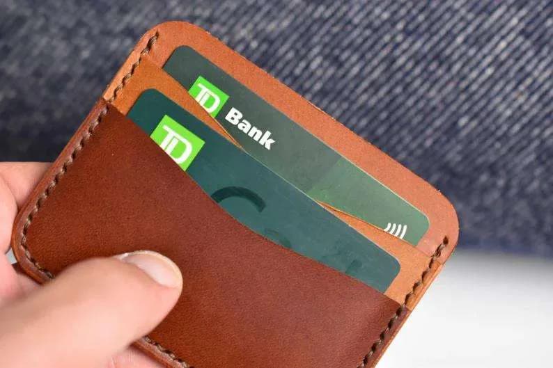 Compact brown leather card holder held in one hand