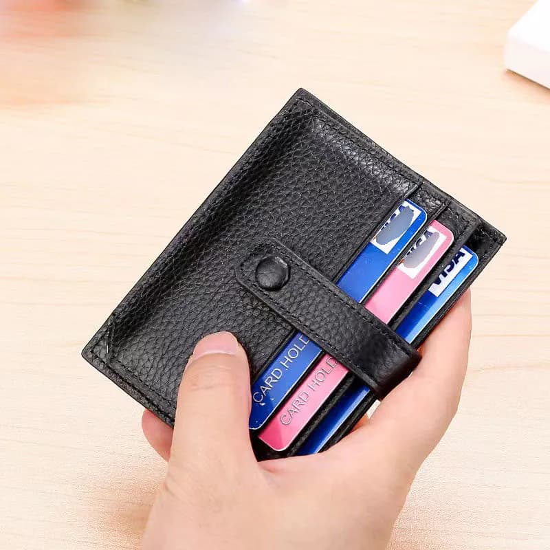 Black snap-closure card holder held with cards inside