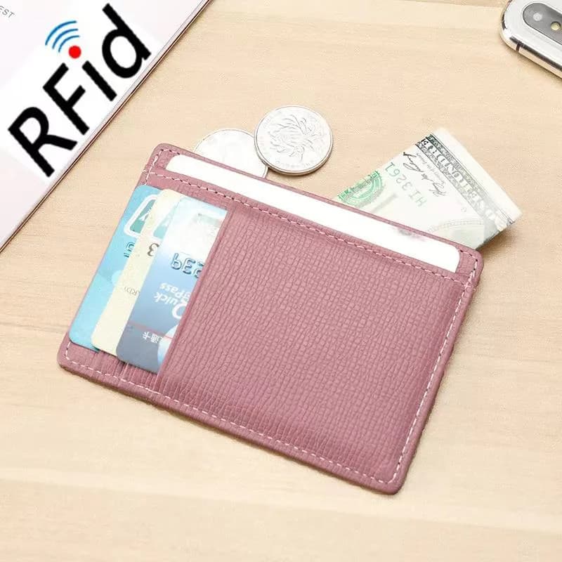 Pink cross-grain RFID card holder with cards and cash on a desk